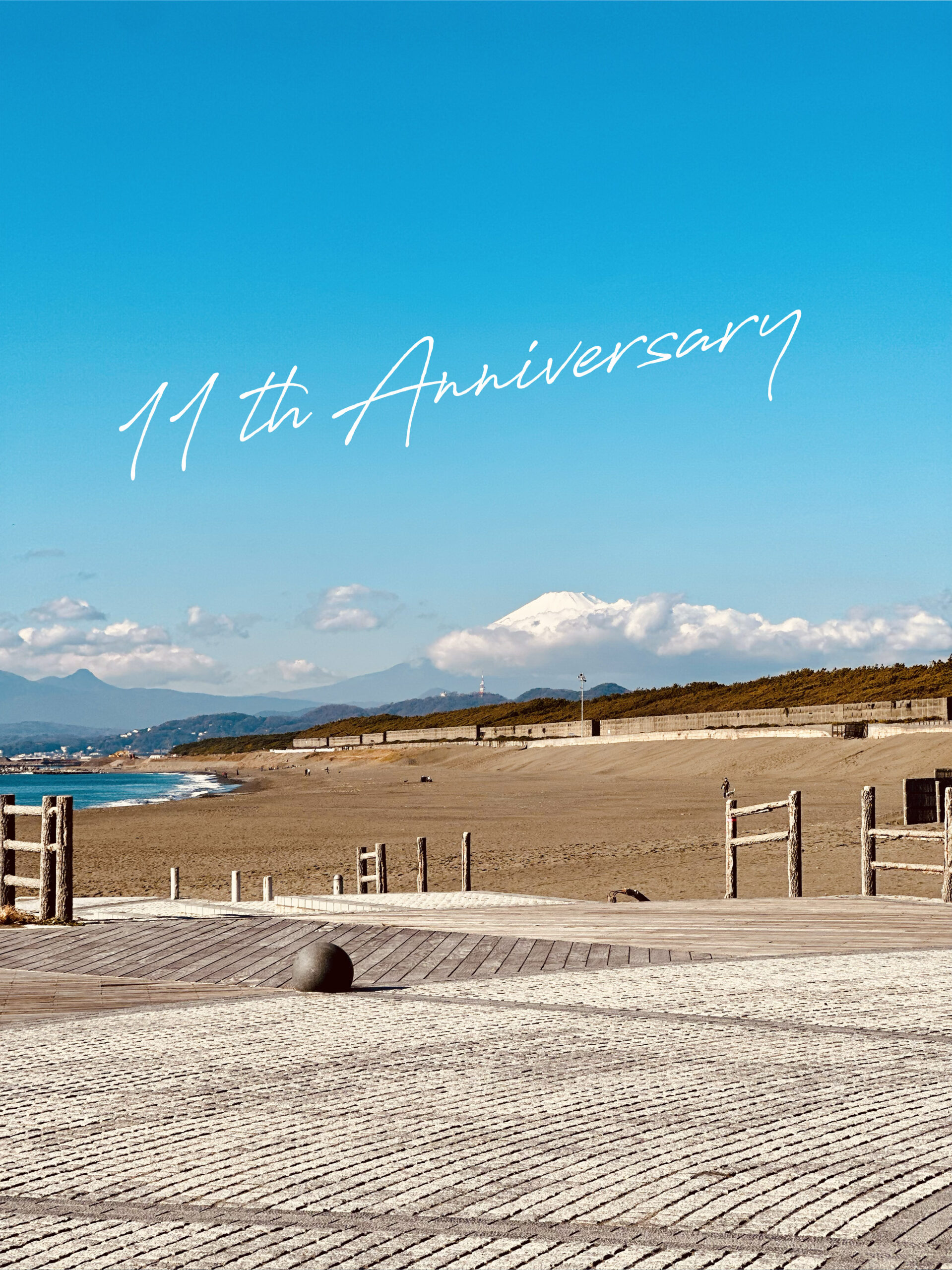 茅ヶ崎の海岸風景に「11th Anniversary」の文字を重ねたCURE創立11周年の記念画像